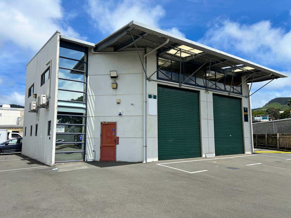 Industrial warehouse with green roller doors and contemporary architecture.