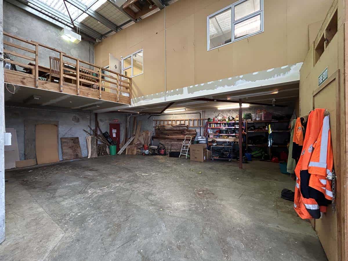 Spacious warehouse interior with storage shelves and safety gear in a modern facility.