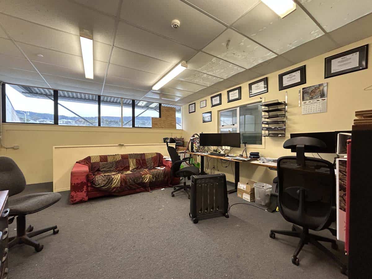 Interior view of a modern office with desks, chairs, and framed certificates.