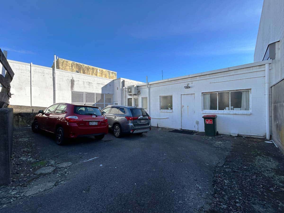 White Lion building exterior with parked cars and blue sky.