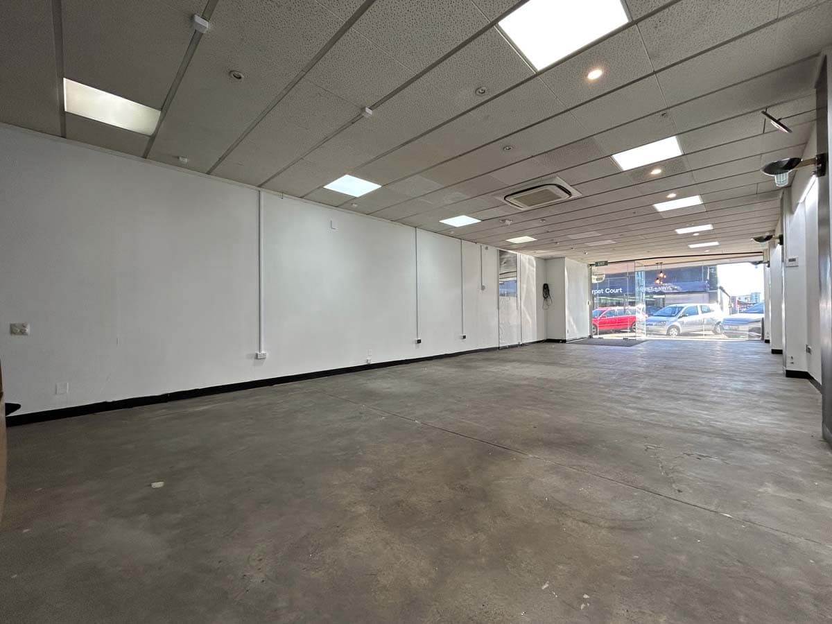 Empty commercial space interior with open floor and ceiling lighting in White Lion building.