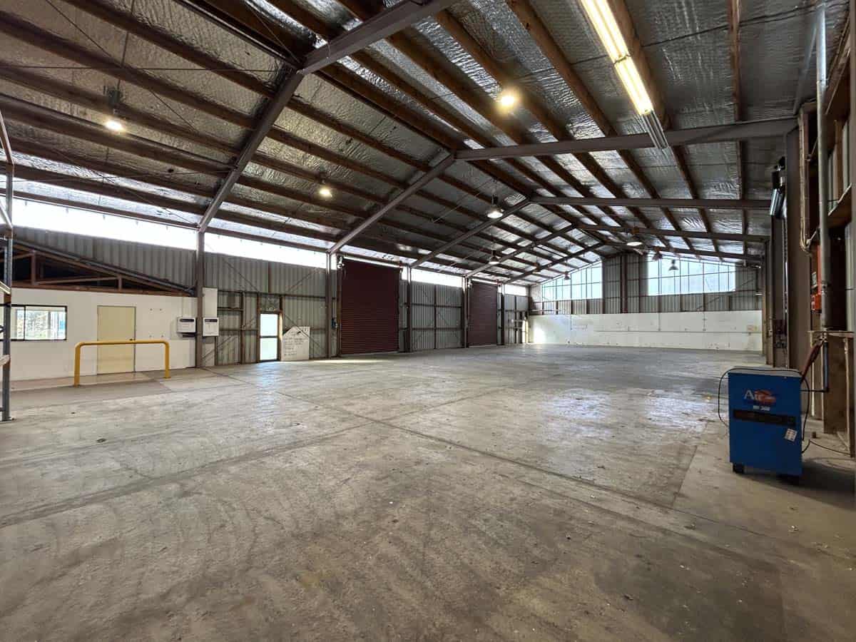 Empty industrial warehouse with high ceilings and metal structure.