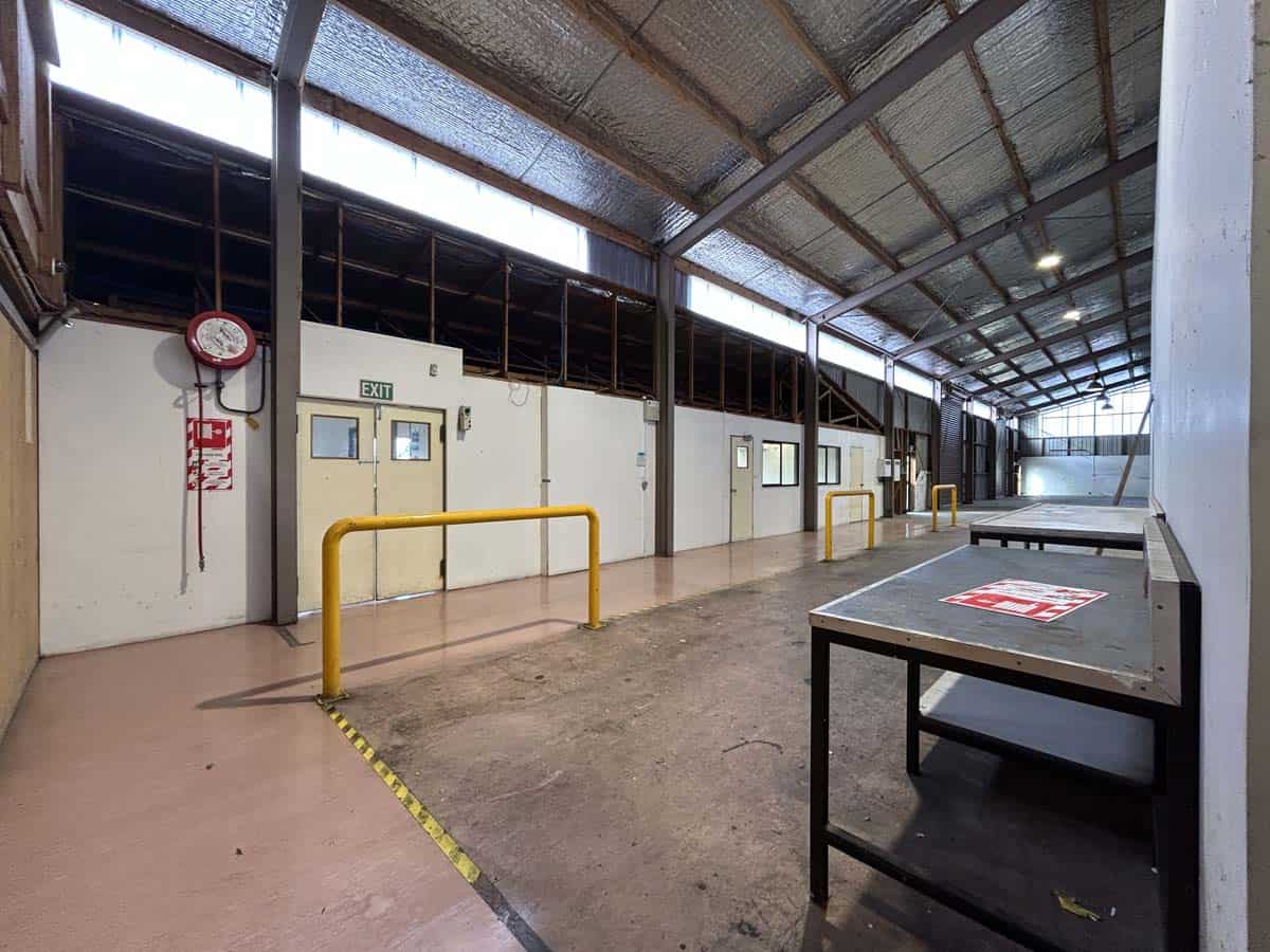 Spacious industrial warehouse with high ceilings, metal roof, and loading area.