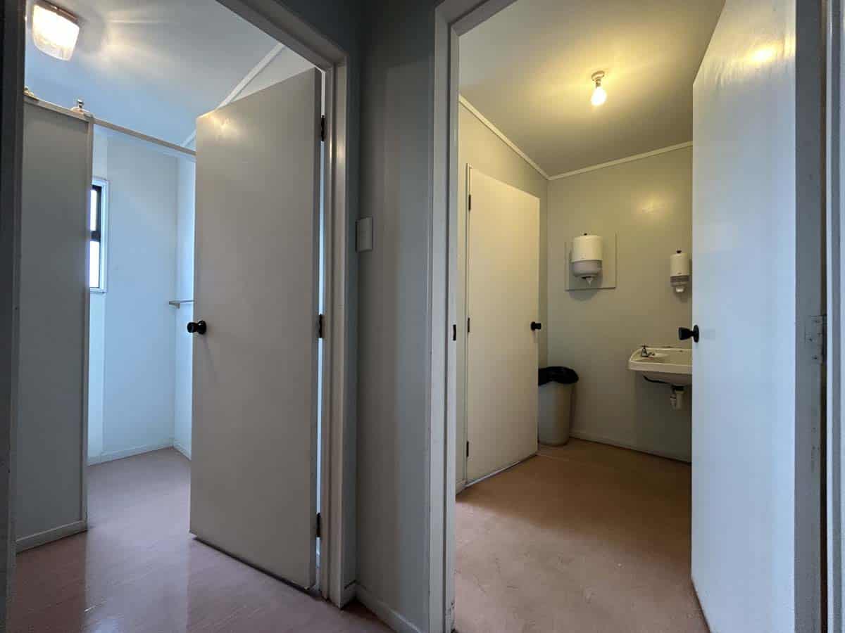 Interior view of a clean, simple restroom with multiple stalls and basic amenities.