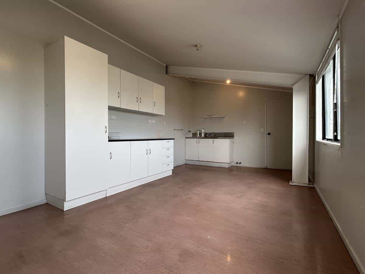 Modern kitchen with white cabinets and large window in a spacious room.