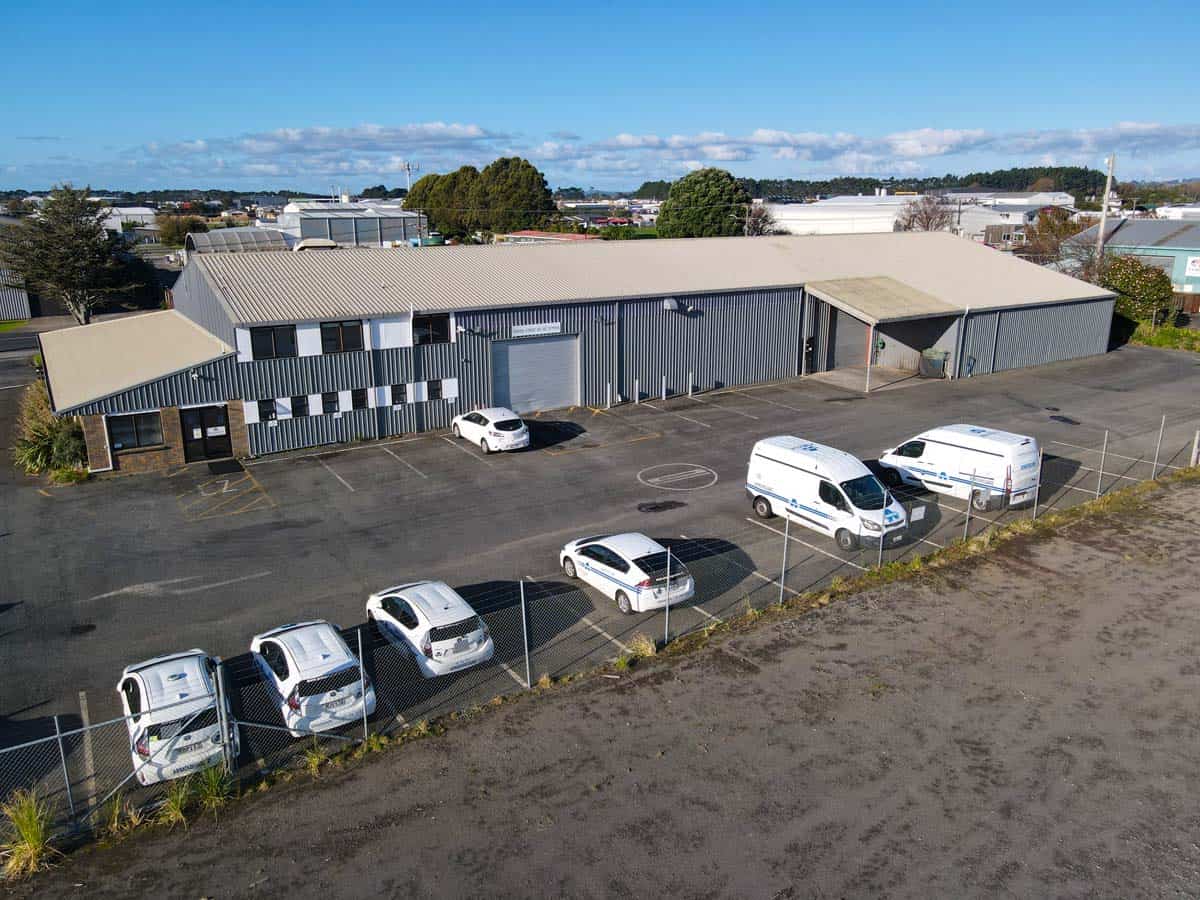 Aerial view of White Lion industrial warehouse with parking lot and vehicles.