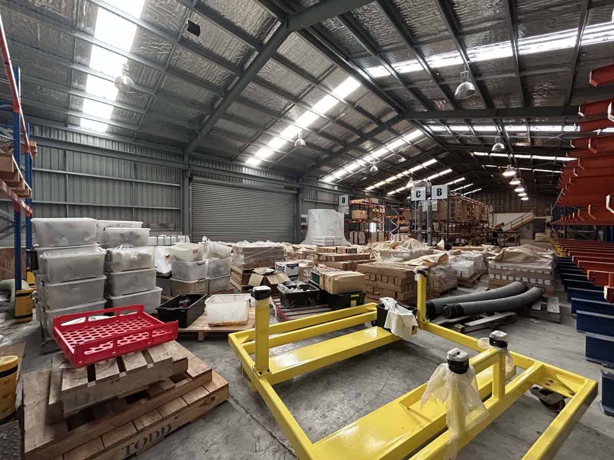 Warehouse interior with industrial shelving, pallets, and storage supplies.