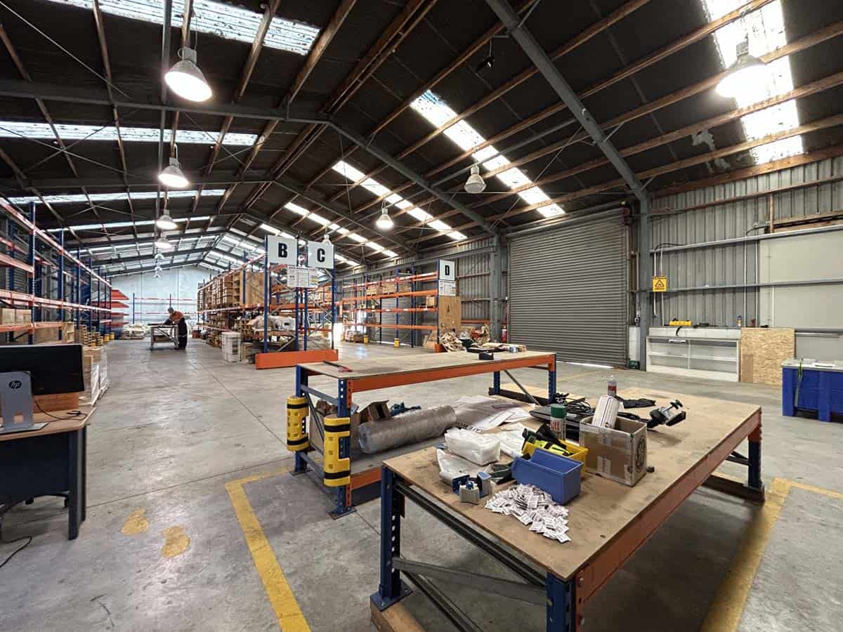 Warehouse interior at White Lion with workstations, storage racks, and industrial equipment.