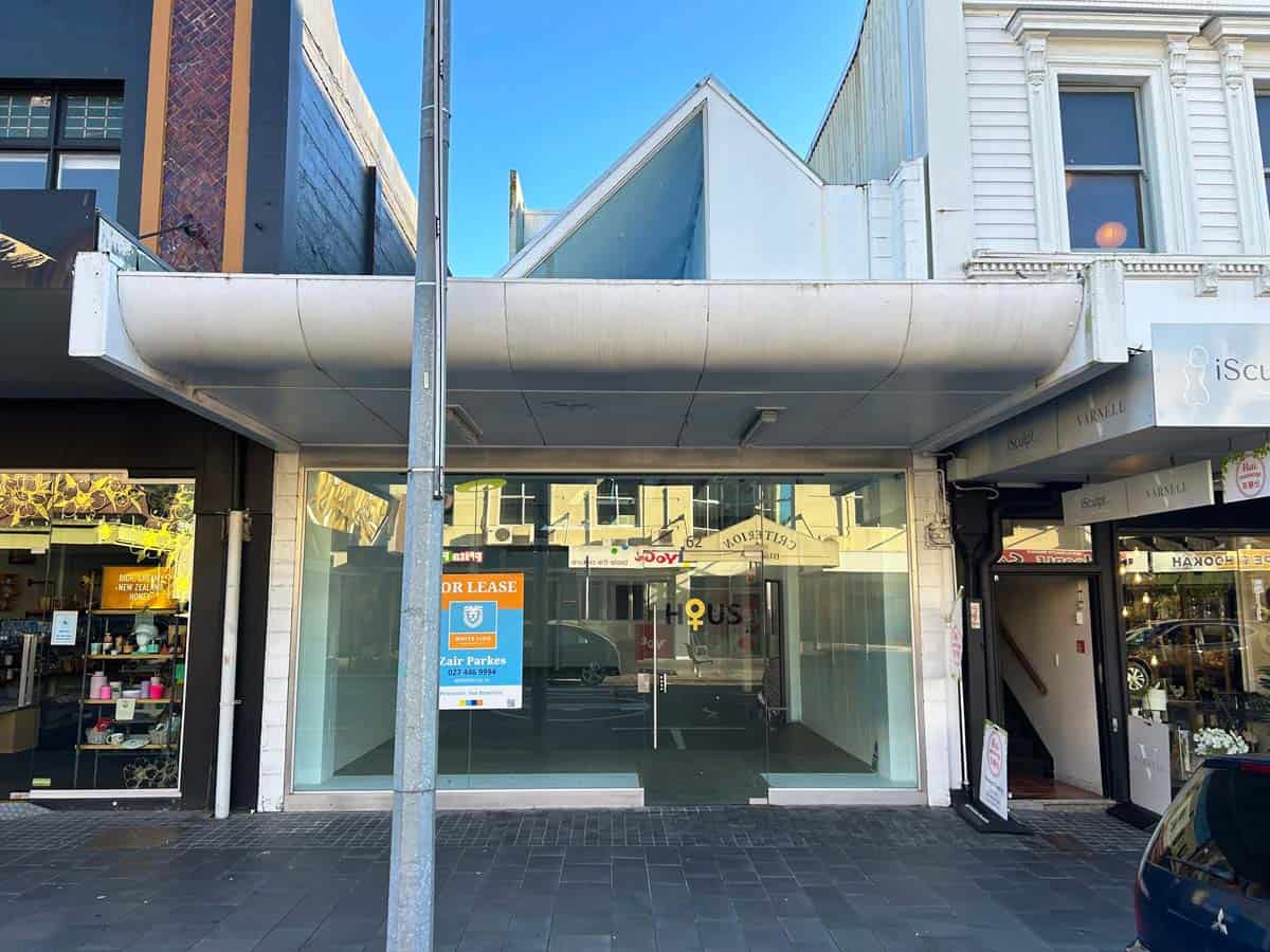 Empty commercial storefront in Auckland, NZ with glass windows and signage.