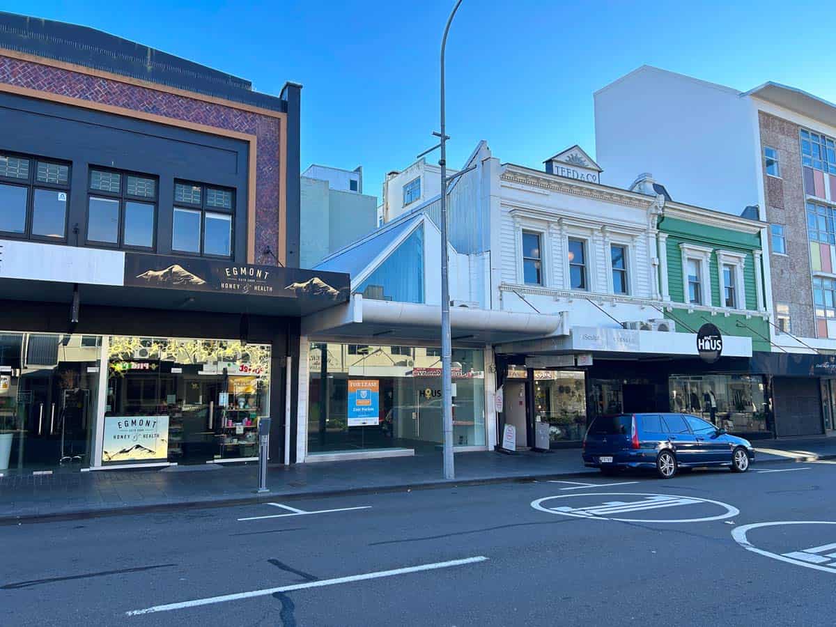 Historic White Lion building with retail shops on a sunny city street.