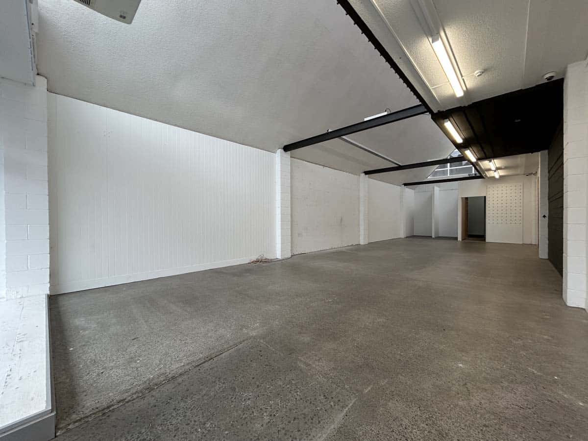 Spacious empty commercial unit with white walls and concrete floor in Auckland.