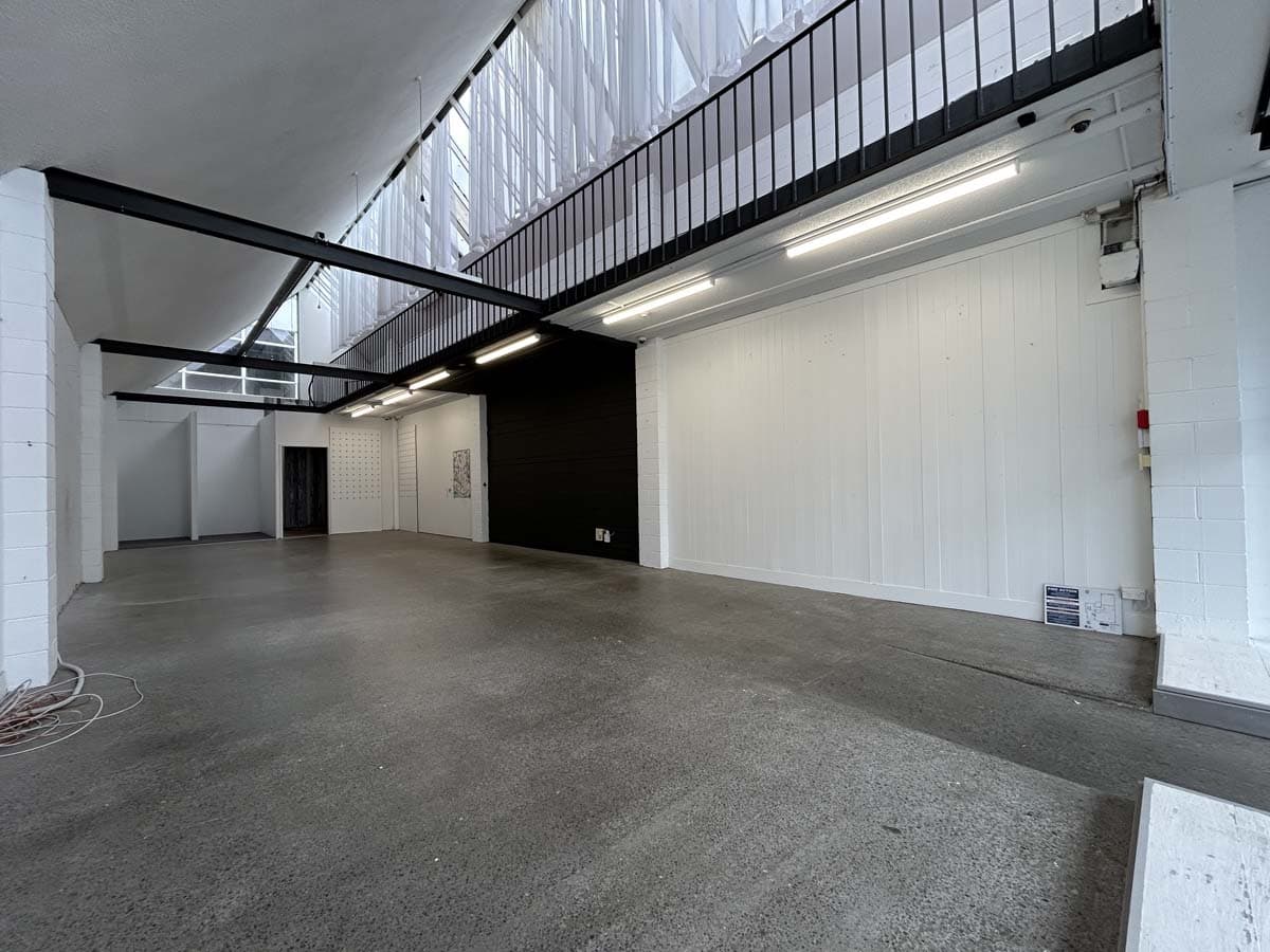 Spacious, modern industrial interior with high ceilings and white walls.