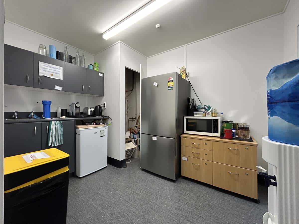 Modern kitchen with appliances, cabinets, and storage in a professional setting.