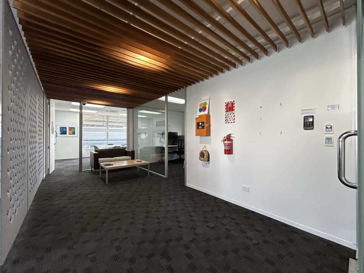 Modern office space with wooden ceiling and glass walls.