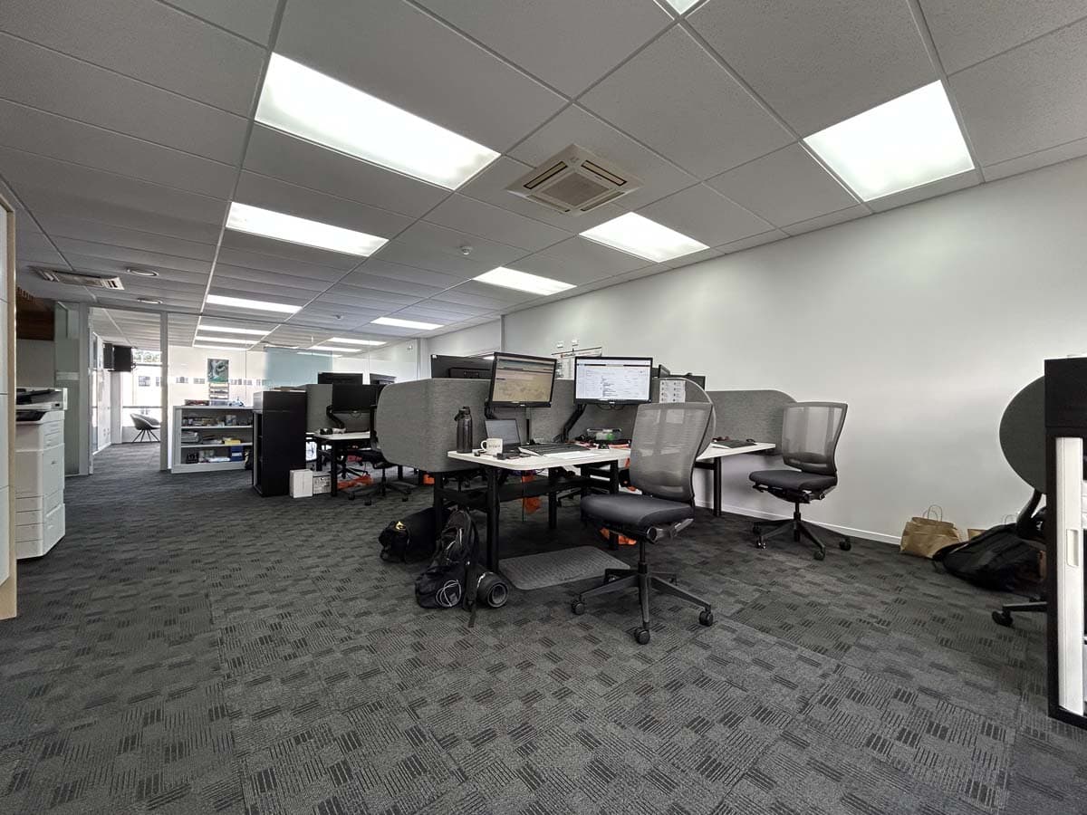 Modern office with multiple desks and computer stations.