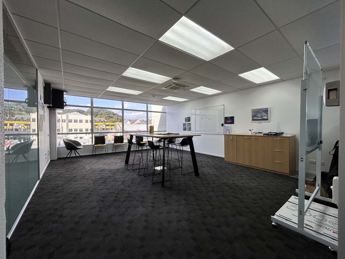 Bright modern office meeting room with large windows and whiteboard.