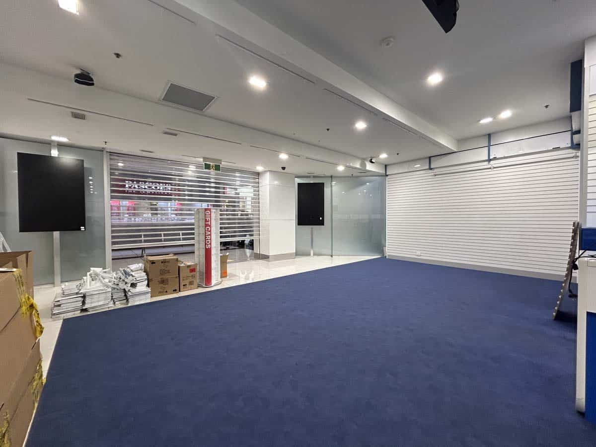 Interior view of a White Lion office space with blue carpet, white walls, and modern lighting.