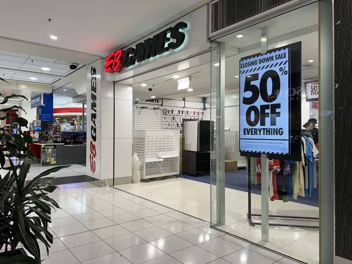 White Lion store in shopping mall with "50% off everything" sale sign.