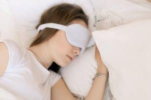 a woman sleeping with a sleep mask