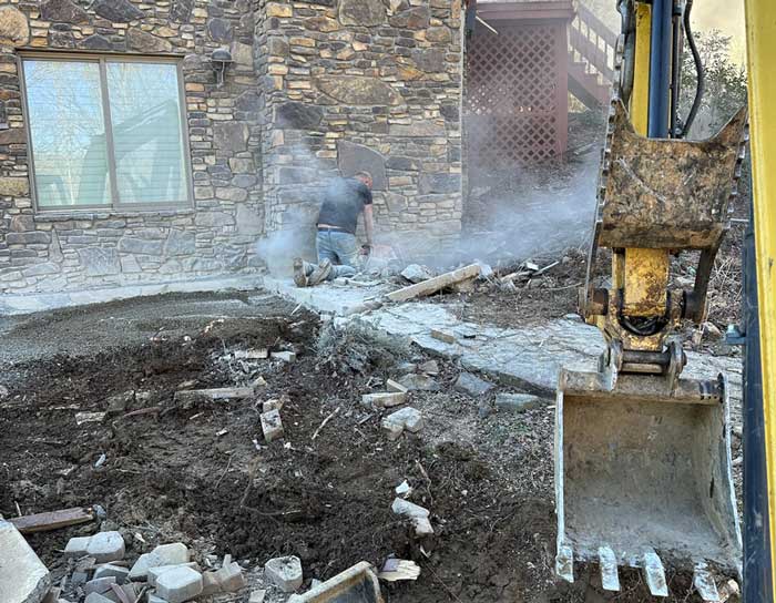 Excavator digging and clearing soil for construction or landscaping project.
