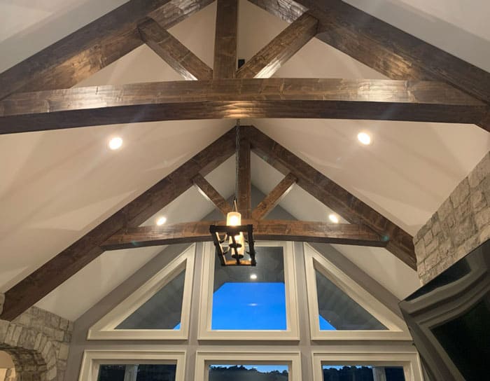 Wooden ceiling beams with lighting in a modern home interior.