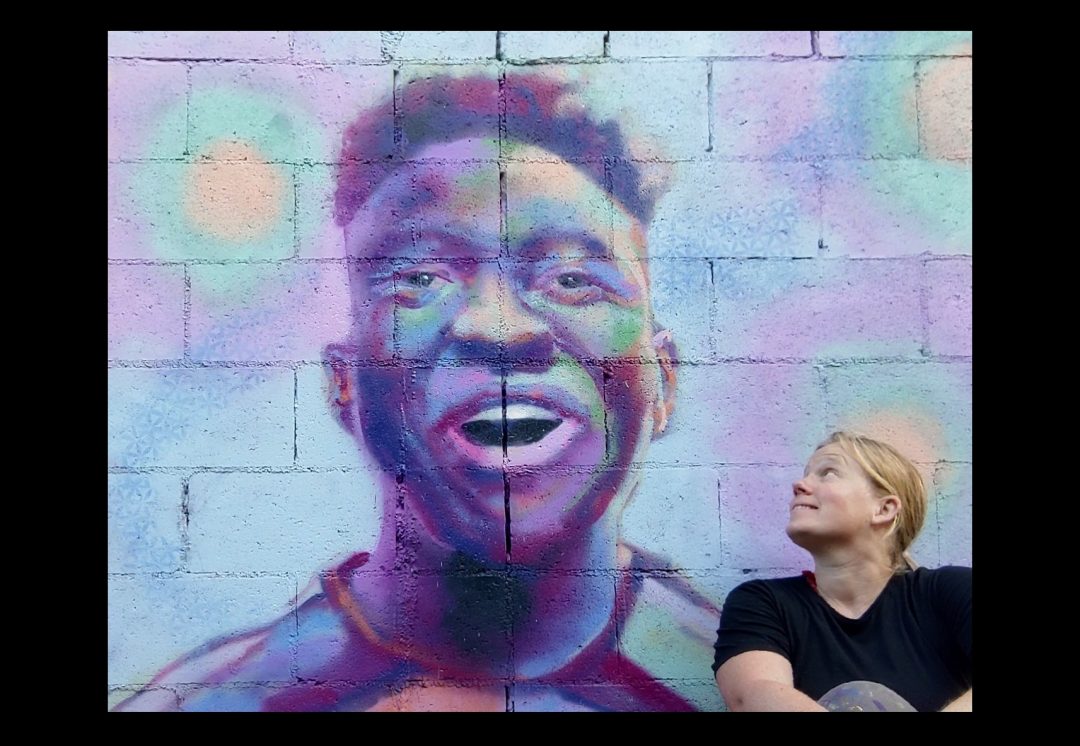 Heidi with a colorful mural portrait painted in Santa Monica