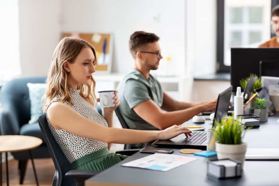 Office workers at desks using laptops, representing full-time employee rights and protections
