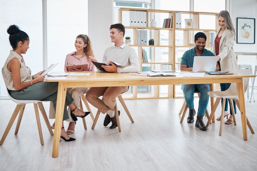 Team collaborating in a bright shared office, illustrating the strategic perks of hot desking