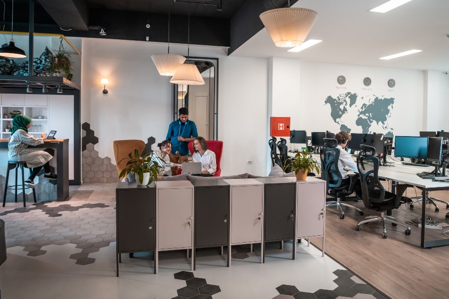 Team collaborates in a bright coworking office with laptops and desks.