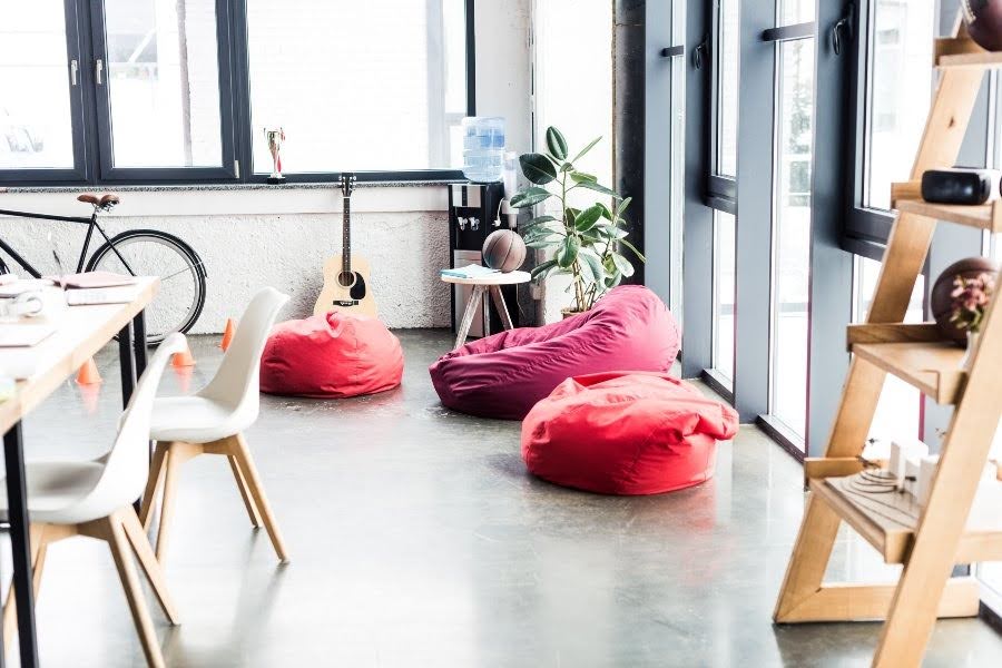 Spacious loft coworking space with bean bags, bikes, and creative work areas.
