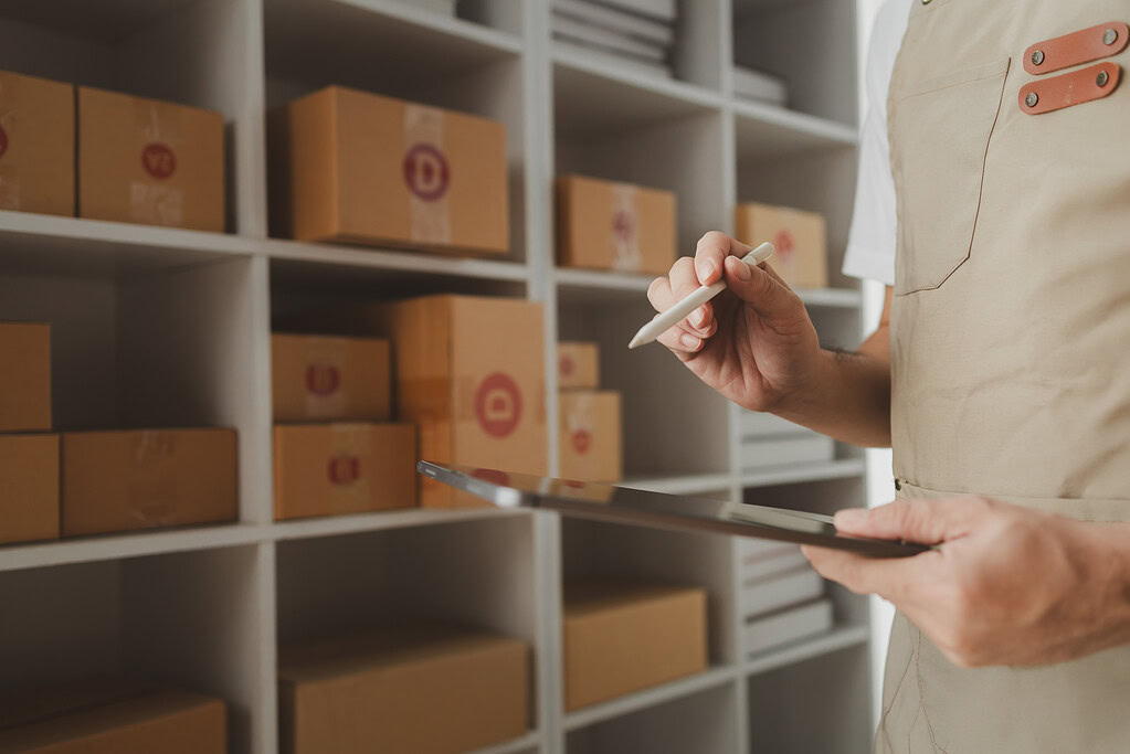 Warehouse worker using a tablet for inventory management for ecommerce stock and order tracking.