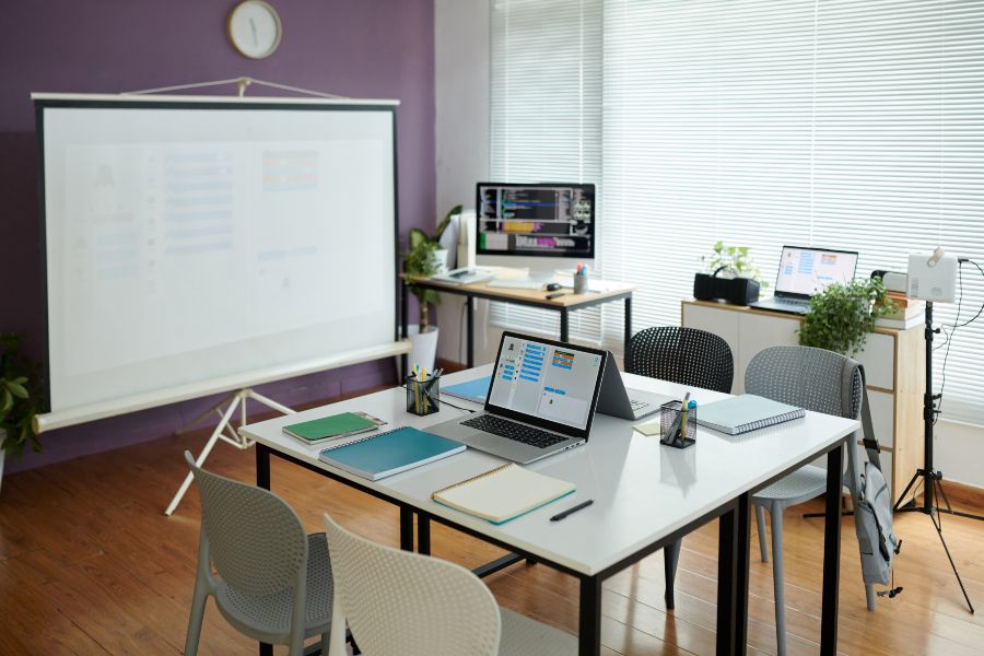 Modern coworking space with laptops and projector, ideal when you've outgrown home business
