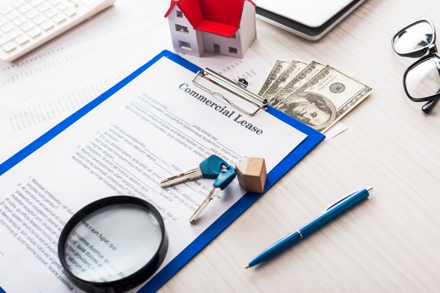 Commercial lease agreement on clipboard with property keys and cash, negotiate commercial rent bond and security deposit terms before signing
