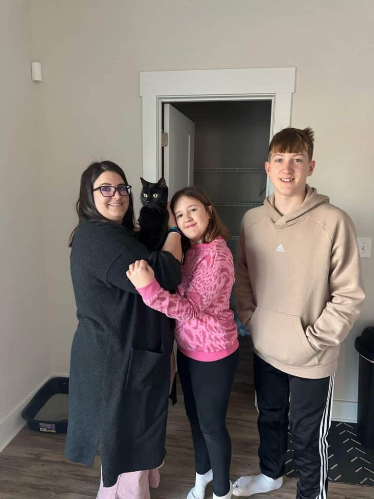 The Daffern family being joyfully reunited with their black cat, Vader.