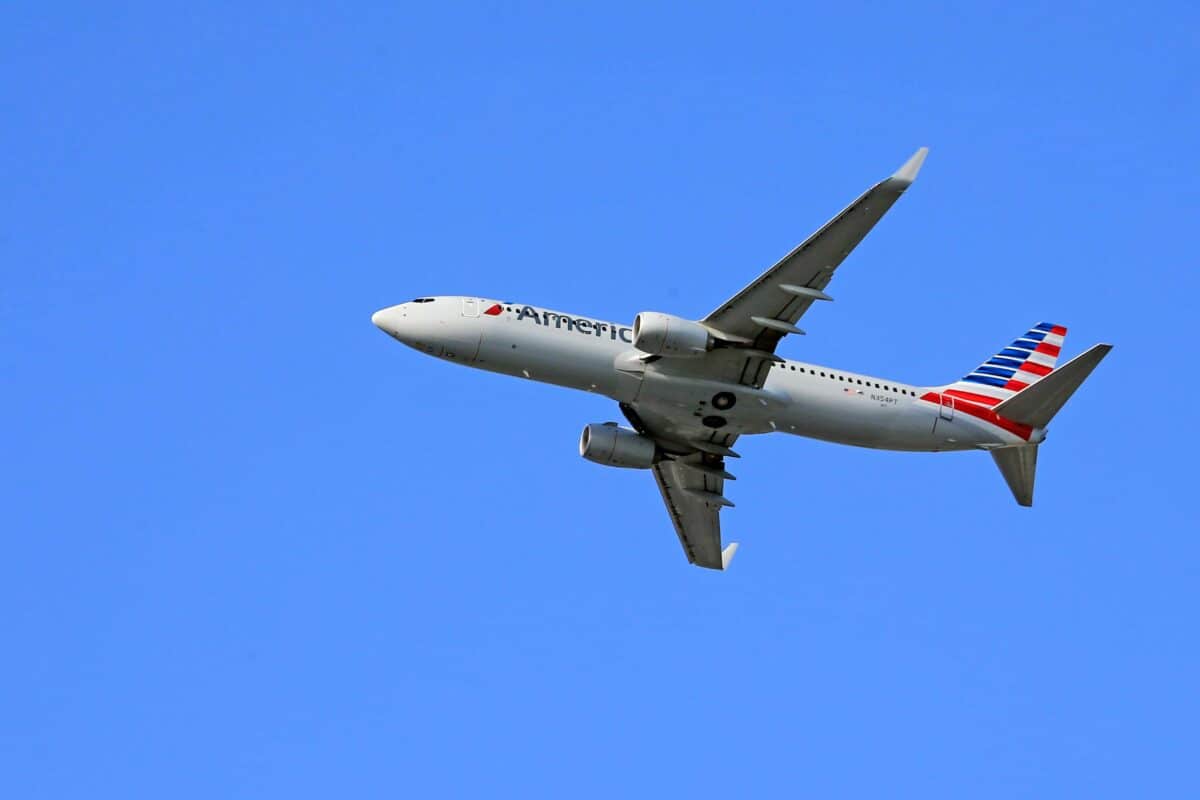 American Airlines aircraft soaring in a clear blue sky, symbolizing the airline’s updated 2025 pet travel policies.