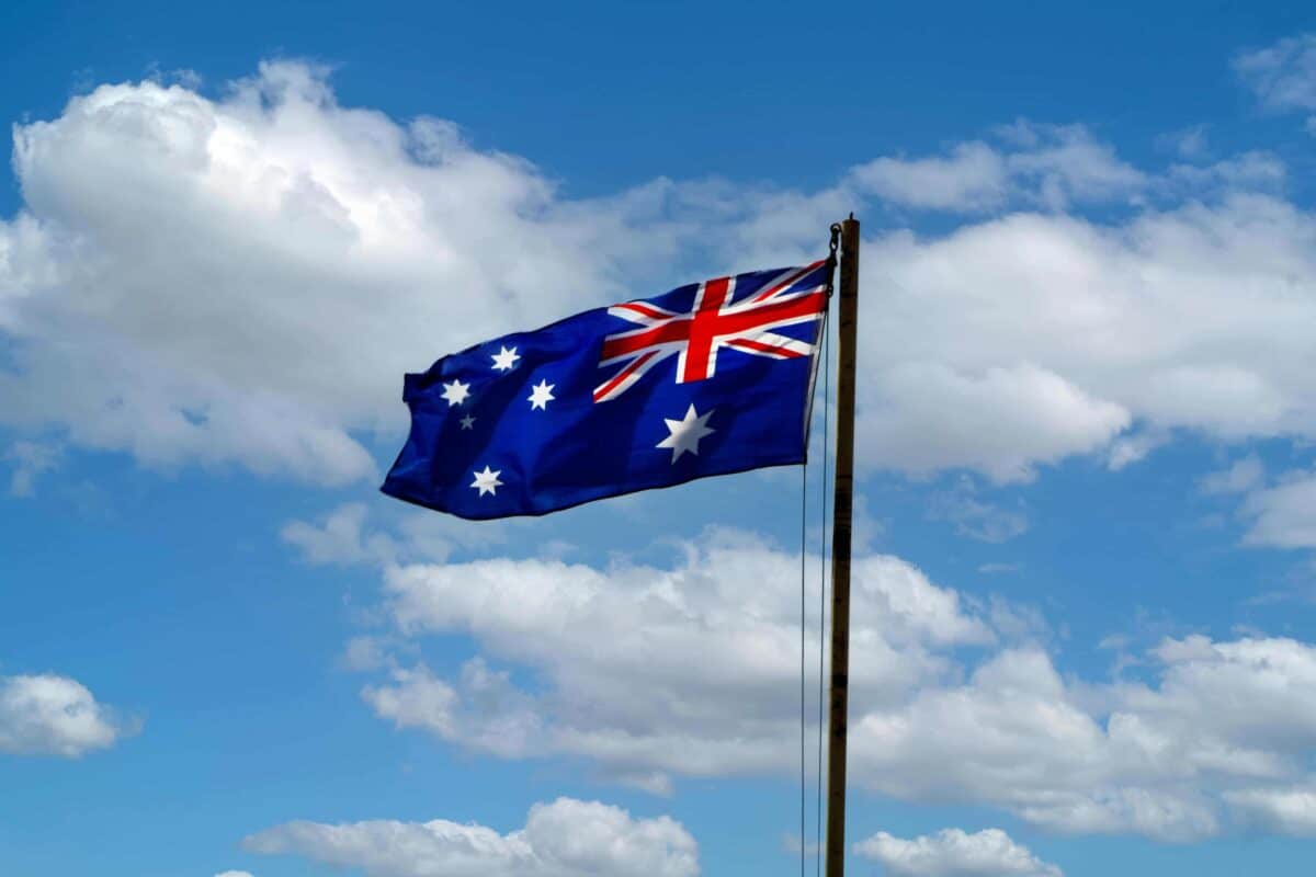 Close-up of an Australian flag with a blue sky in the background, symbolizing USA to Australia dog relocation planning.