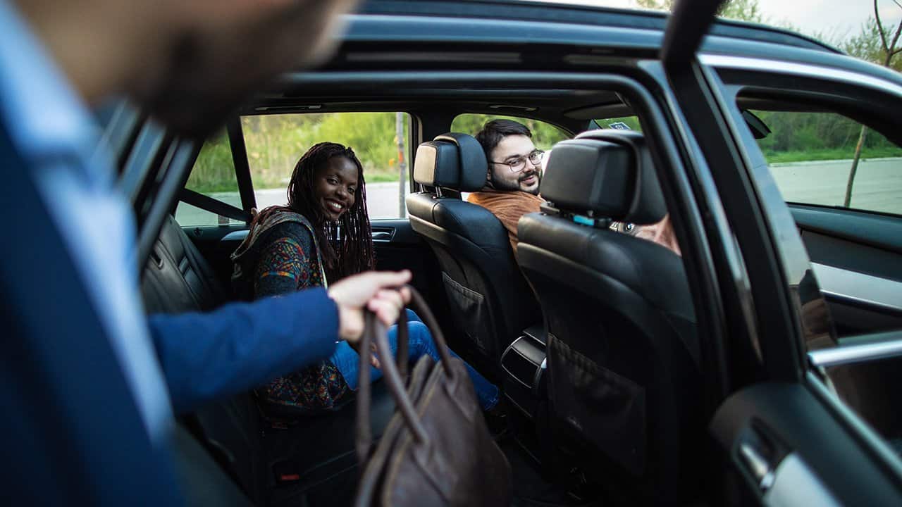Two riding individuals welcoming a third rider to car pool together