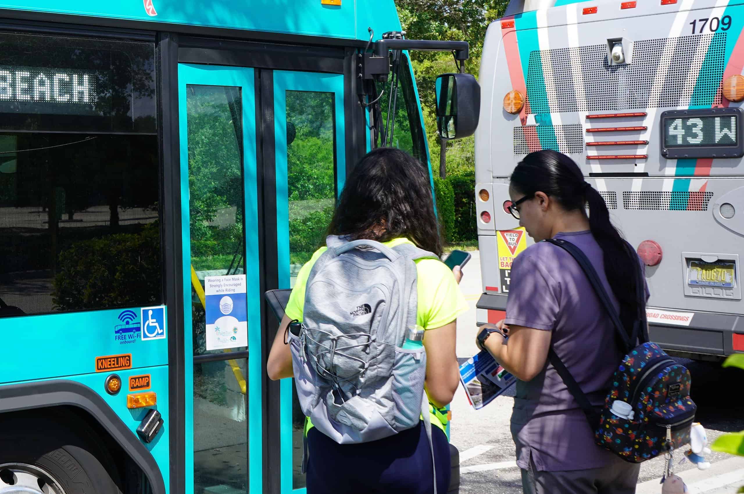 Two commuters about to step onto the PalmTran bus in West Palm Beach, Florida