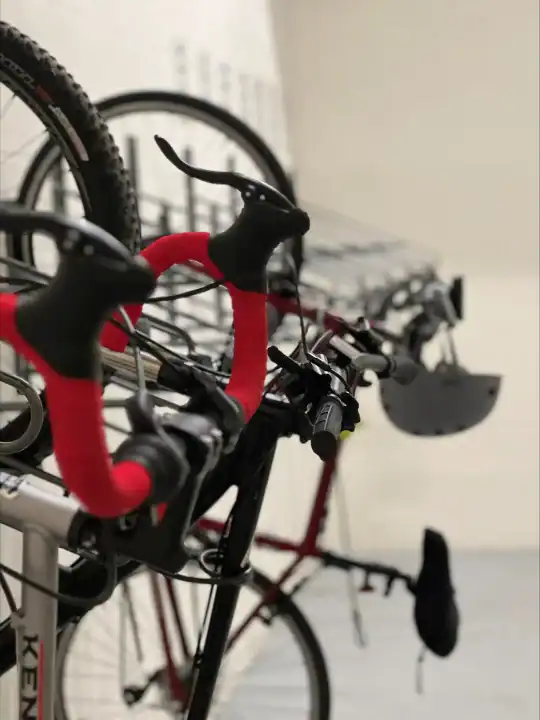 Close-up of a black and red bicycle handlebar with gear shifters and brake levers.