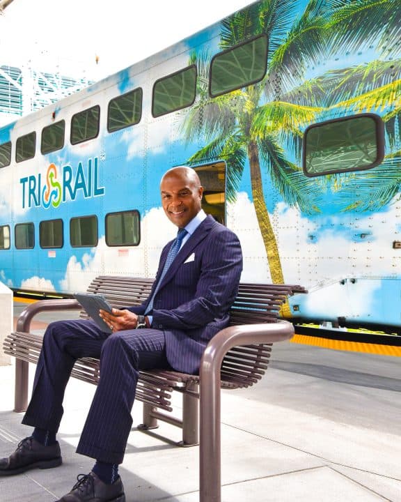 Gentleman sits on a bench awaiting his commute ride with Tri-Rail.