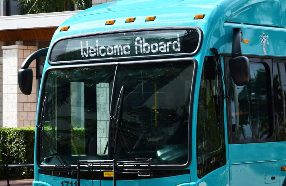 Blue bus with 'Welcome Aboard' sign at the front.