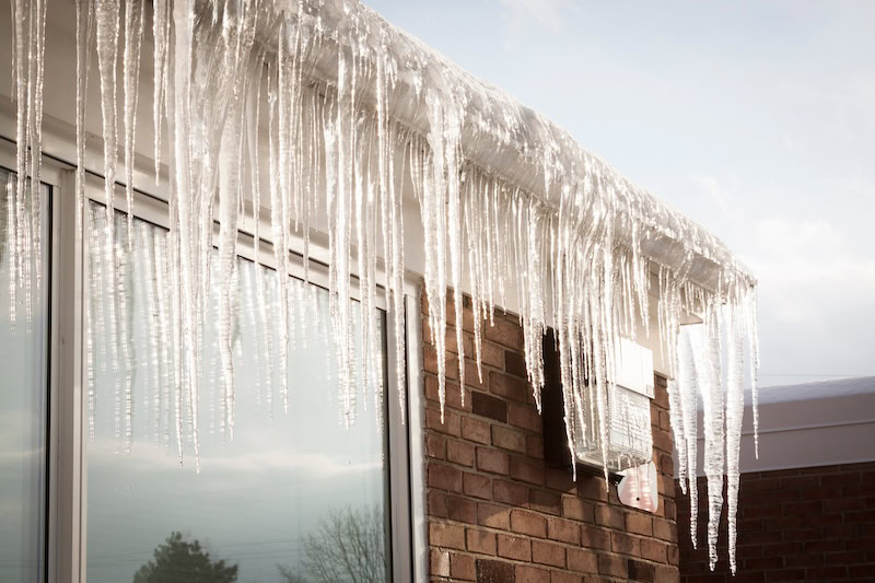 Ice dam buildup causing roof damage on a Colorado home in winter