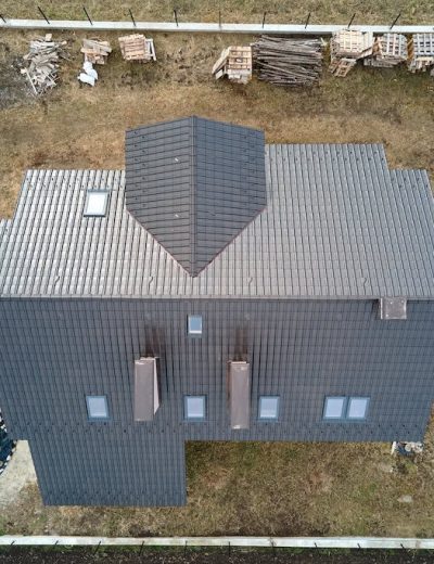 Aerial view of house roof top covered with ceramic shingles. Tiled covering of building under construction Aerial view of house roof top covered with ceramic shingles. Tiled covering of building under construction.