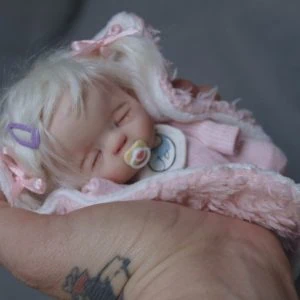 ob11 doll with a pacifier in its hand.