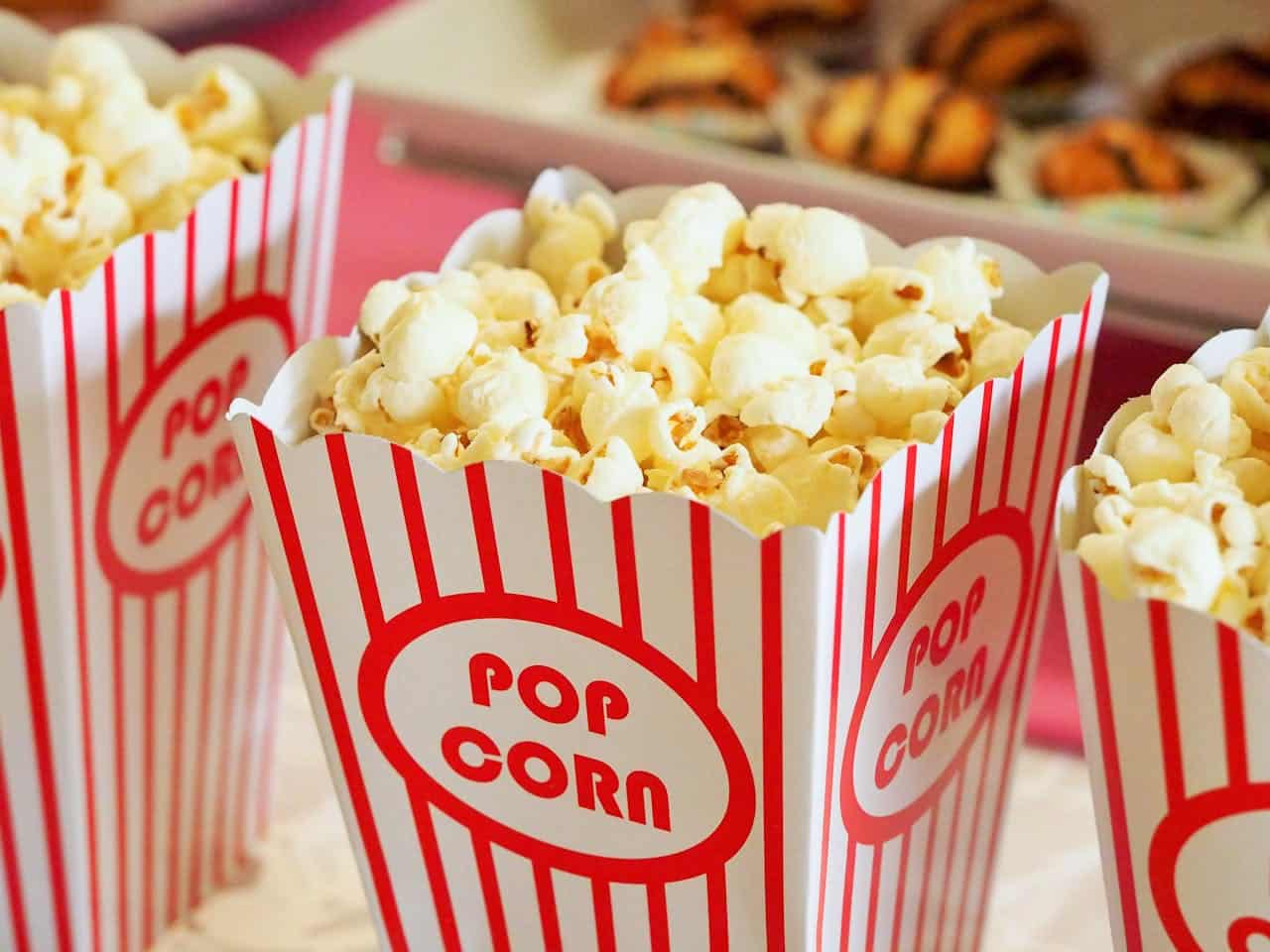 services-04 Close-up of gourmet popcorn in classic red and white striped boxes, perfect cinema snack.