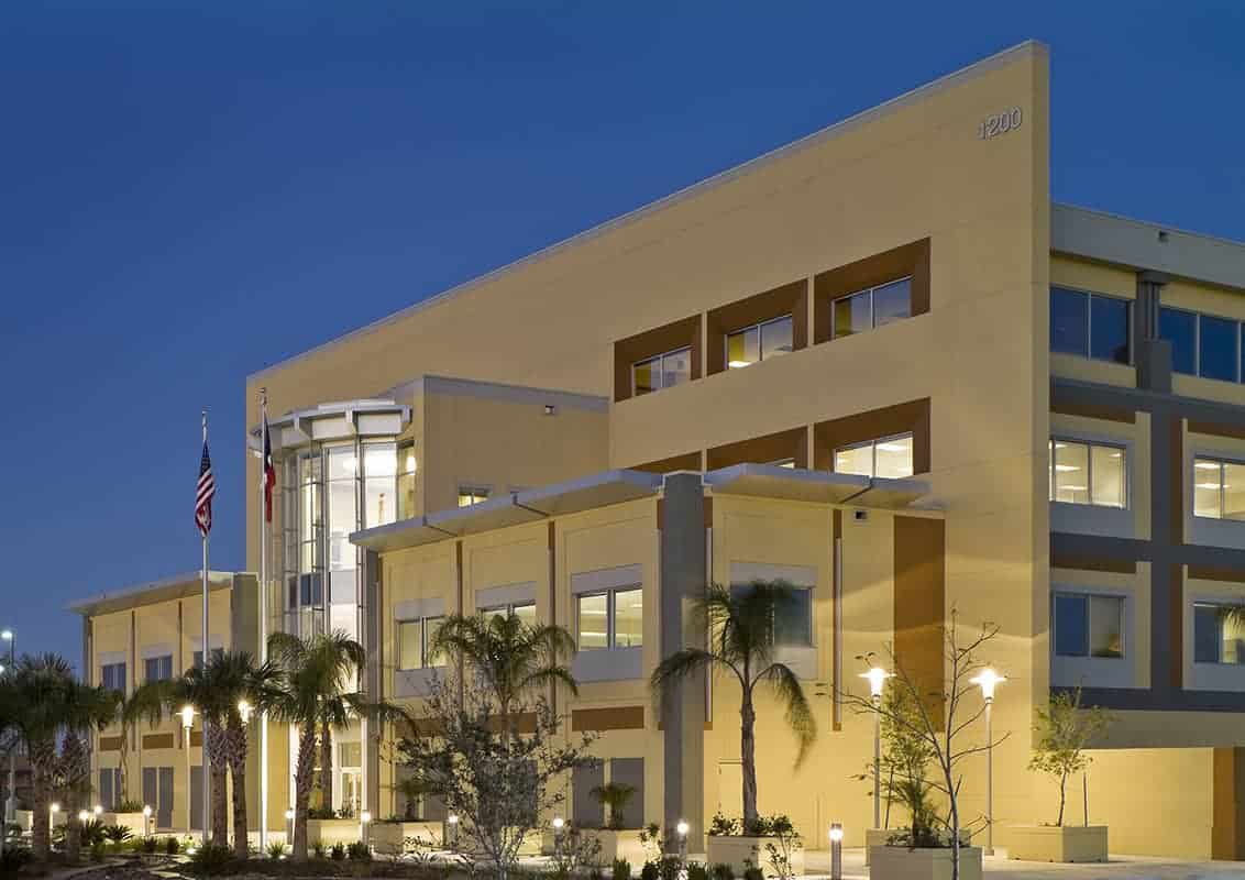 Modern office building at dusk with flags.