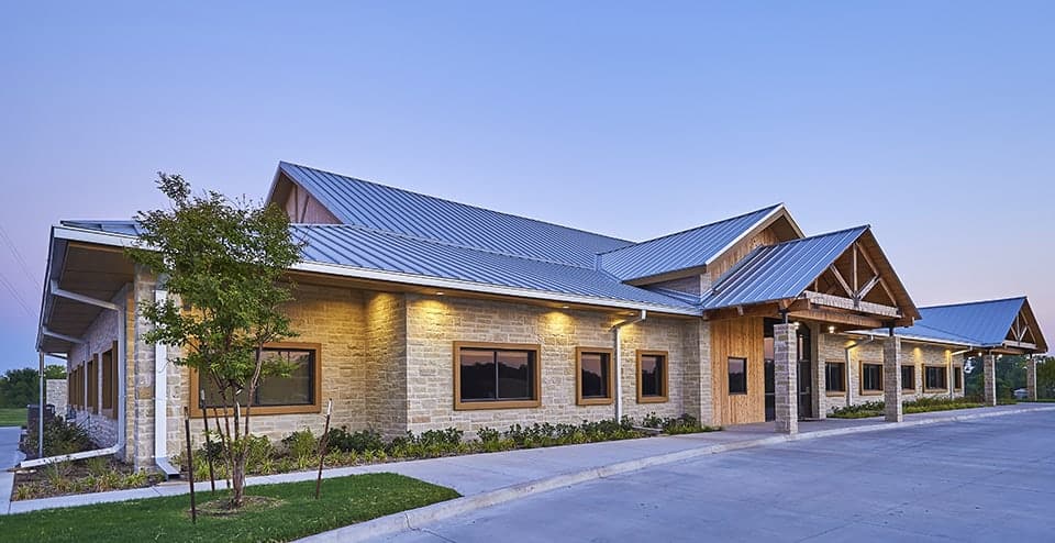 Modern building with metal roof and stone facade.