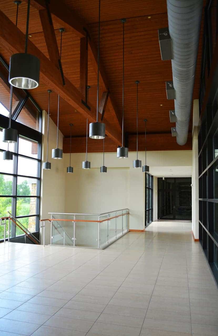 Modern hallway with hanging lights and windows.