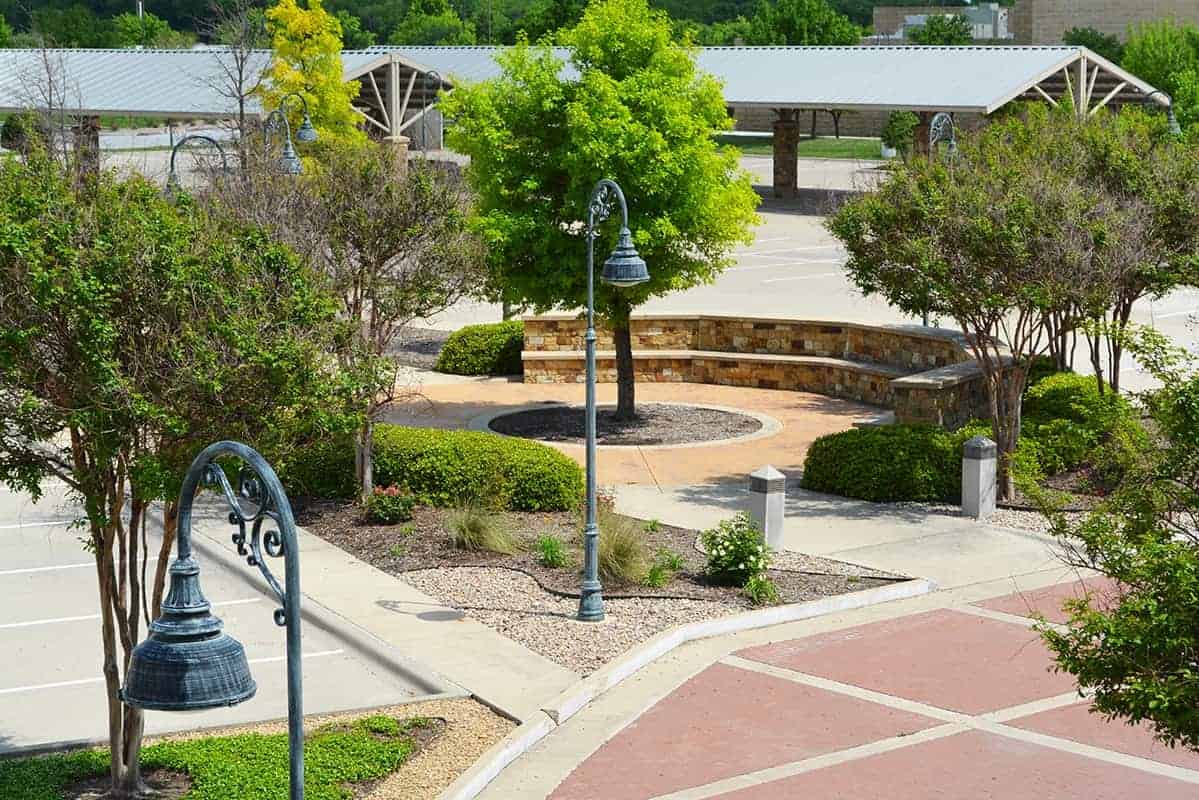 Outdoor seating area with trees and shrubs.