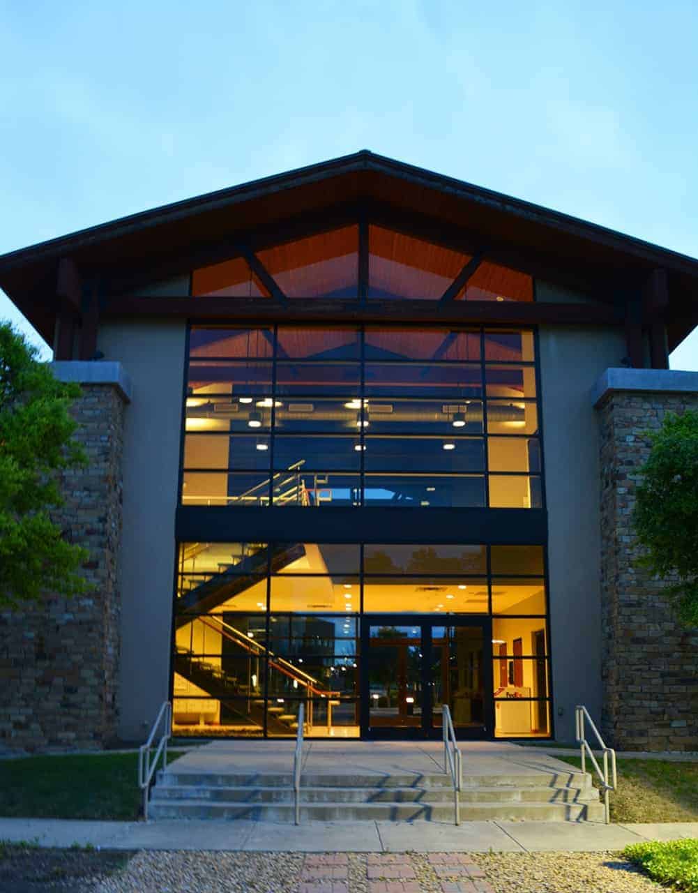 Modern building with large glass windows at dusk.